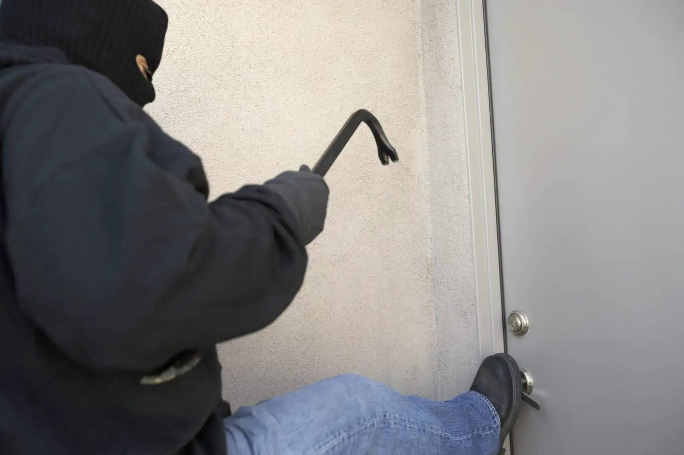 burglar kicking the door of house